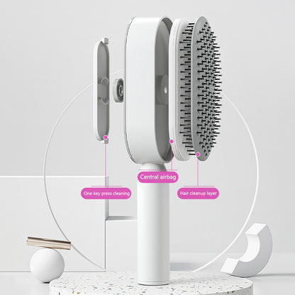 One click hair release button being pushed on the back of a self cleaning brush