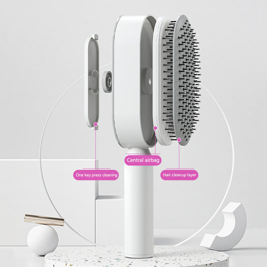 One click hair release button being pushed on the back of a self cleaning brush