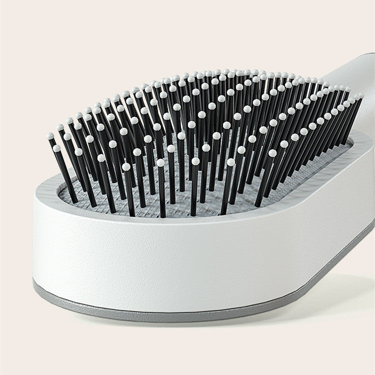 Soft ball tipped bristles on a flexible cushioned massage scalp comb